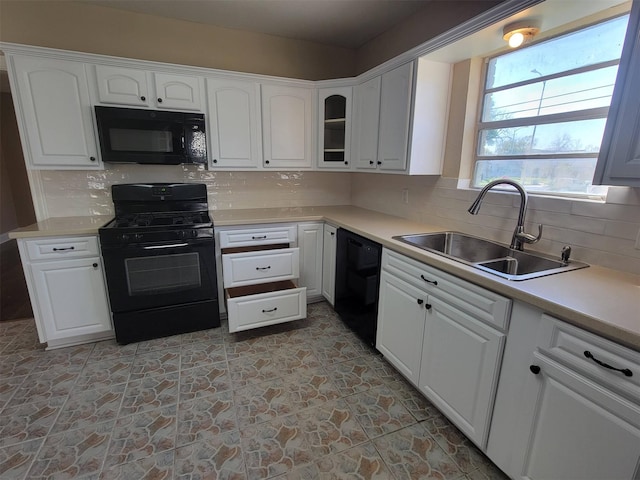 2601 Wheeler St, Houston, TX 77004 - kitchen with black appliances, a sink, white cabinets, and backsplash