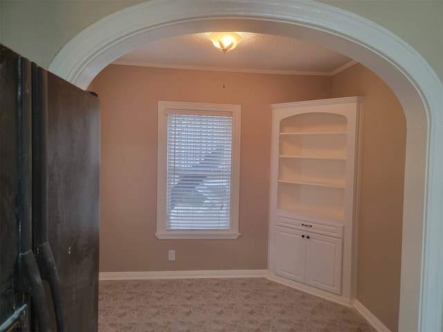 interior space with ornamental molding, a textured ceiling, and plenty of natural light