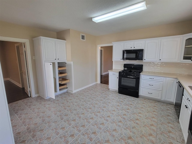 2601 Wheeler St, Houston, TX 77004 - kitchen featuring black appliances, white cabinets, light countertops, backsplash, and baseboards
