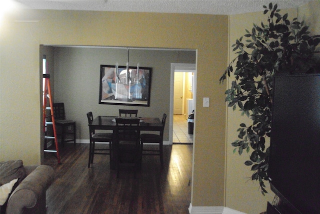 dining room with wood-type flooring and a textured ceiling