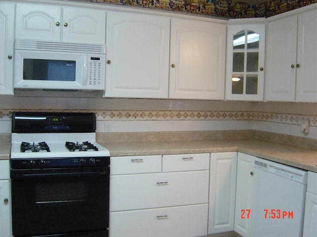2601 Wheeler St, Houston, TX 77004 - kitchen with white appliances, glass insert cabinets, and white cabinets