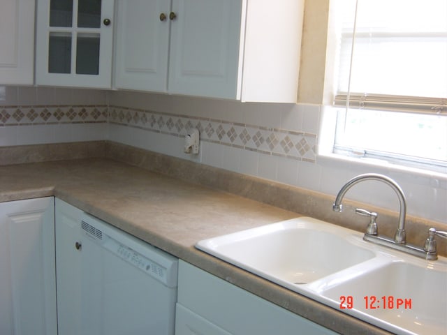 kitchen with white cabinets, sink, and white dishwasher