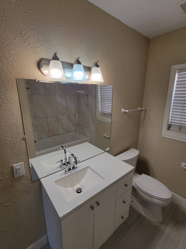 bathroom with toilet, hardwood / wood-style flooring, and vanity