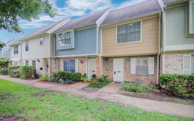 townhome / multi-family property with a front lawn