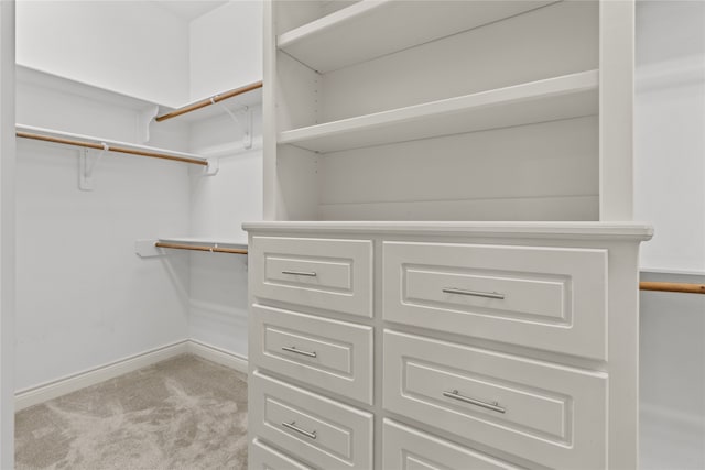 walk in closet featuring light colored carpet