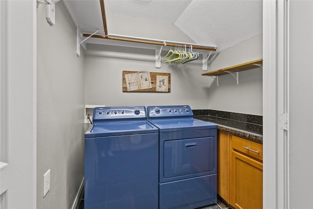 washroom with a textured ceiling and separate washer and dryer