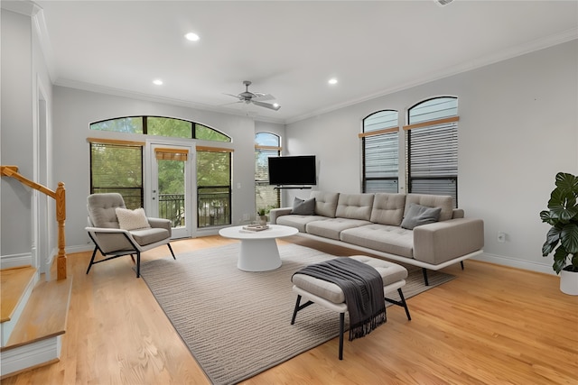 living room with light hardwood / wood-style flooring, ornamental molding, and ceiling fan