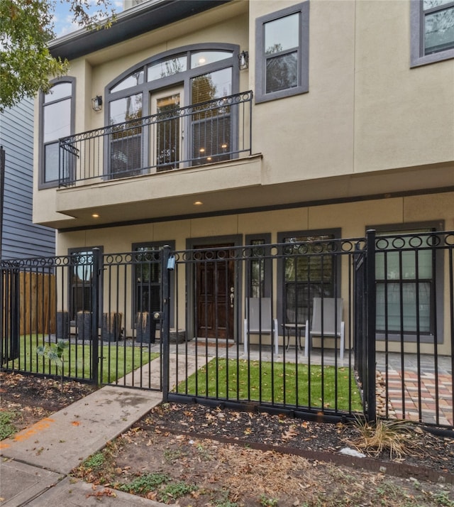 view of front of property with a front yard and a balcony