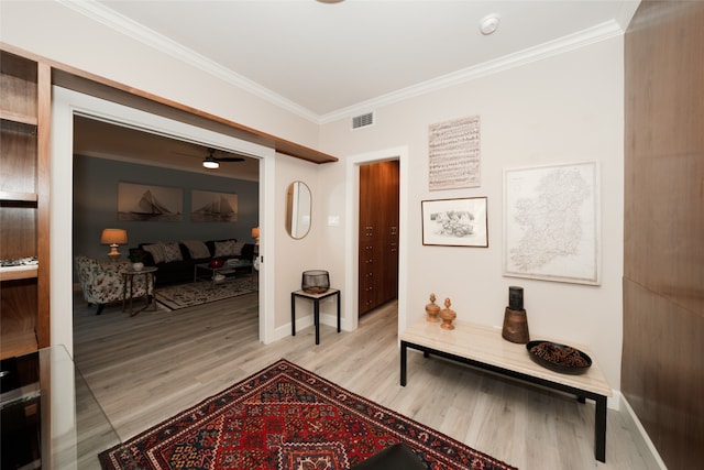 corridor with ornamental molding and light wood-type flooring