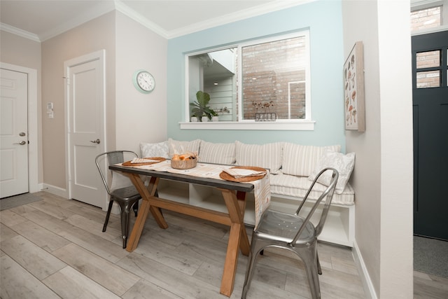 dining room featuring crown molding, breakfast area, and light hardwood / wood-style floors