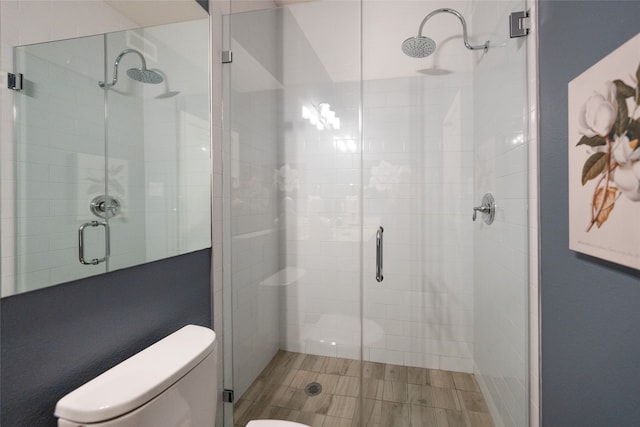 bathroom with toilet and a shower with shower door