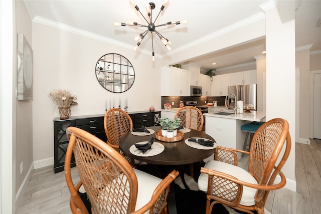 dining room featuring sink, light hardwood / wood-style flooring, a notable chandelier, and crown molding