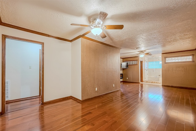 empty room featuring ornamental molding, hardwood / wood-style floors, a textured ceiling, and ceiling fan