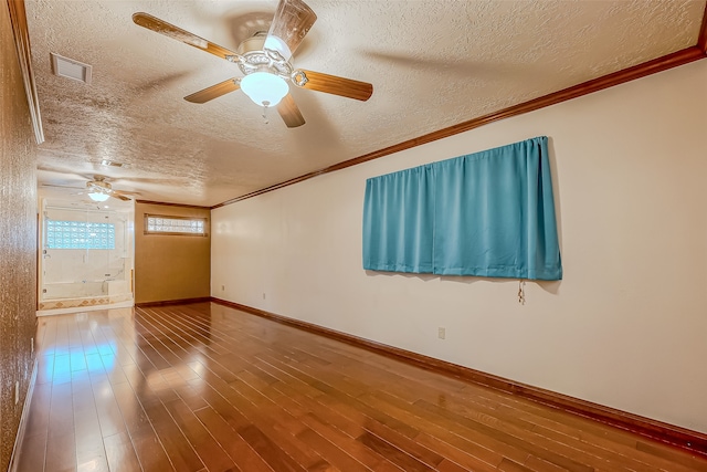 empty room with ornamental molding, a textured ceiling, and hardwood / wood-style flooring