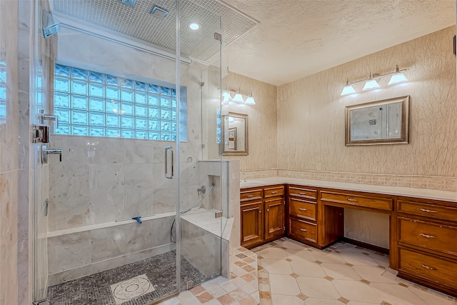 bathroom featuring vanity, an enclosed shower, and a textured ceiling