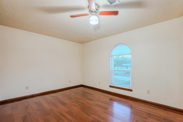 spare room featuring a textured ceiling and hardwood / wood-style flooring