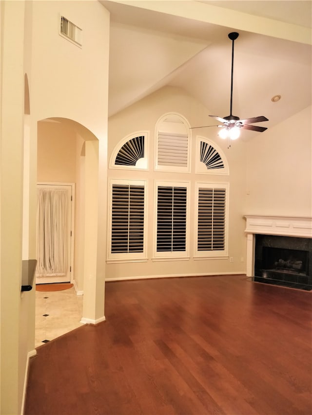 unfurnished living room with hardwood / wood-style floors, high vaulted ceiling, and ceiling fan