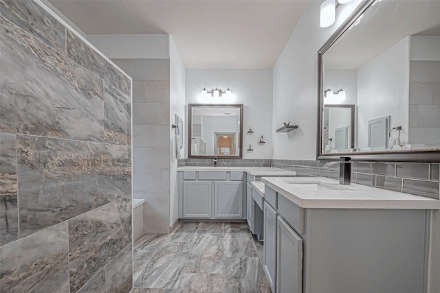 bathroom with vanity and tile walls