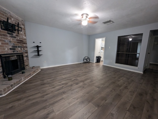 unfurnished living room with a fireplace, a textured ceiling, dark hardwood / wood-style flooring, and ceiling fan