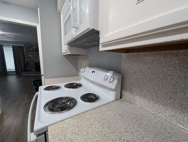 kitchen featuring white cabinets, dark wood-type flooring, and white appliances