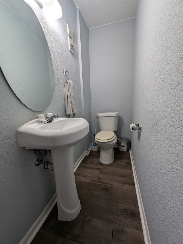 bathroom with toilet and hardwood / wood-style flooring