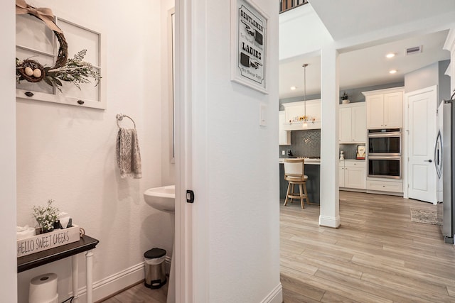 bathroom with backsplash and wood-type flooring