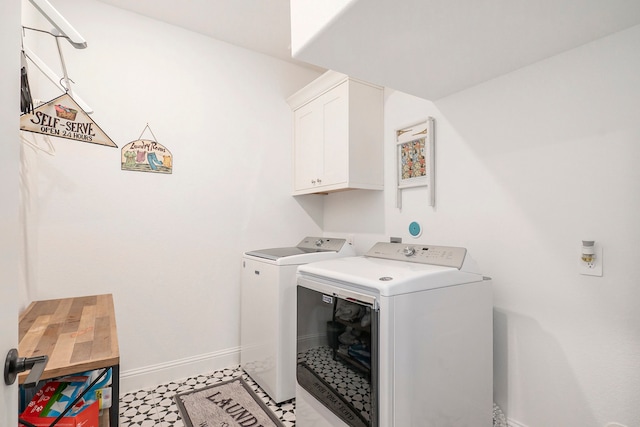 washroom with cabinets and washing machine and clothes dryer