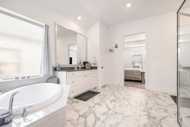 bathroom with vanity and tiled tub