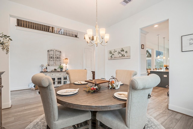 dining area with hardwood / wood-style flooring and a chandelier