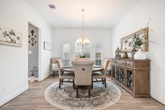 dining space with a notable chandelier and light wood-type flooring