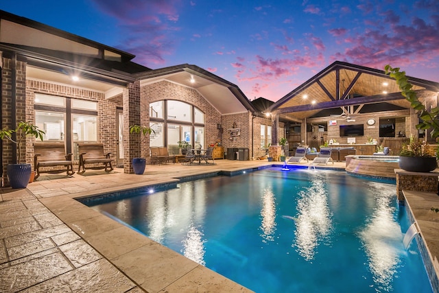 view of swimming pool with an in ground hot tub, pool water feature, a patio area, and ceiling fan