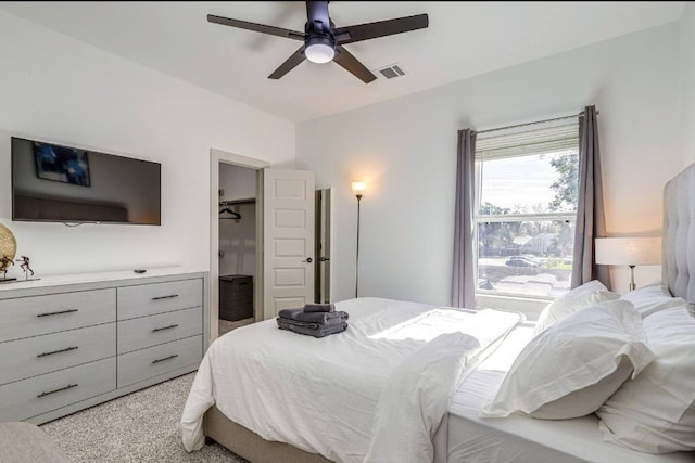 carpeted bedroom featuring a spacious closet, ceiling fan, and a closet