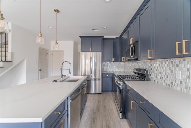 kitchen featuring blue cabinetry, stainless steel appliances, sink, and light wood-type flooring