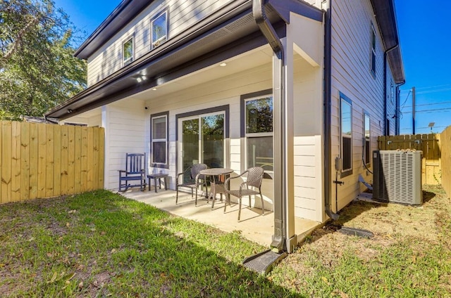 rear view of property featuring a patio area, cooling unit, and a lawn