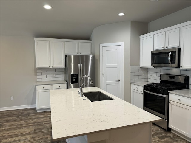 kitchen featuring dark wood-type flooring, recessed lighting, tasteful backsplash, a sink, and appliances with stainless steel finishes