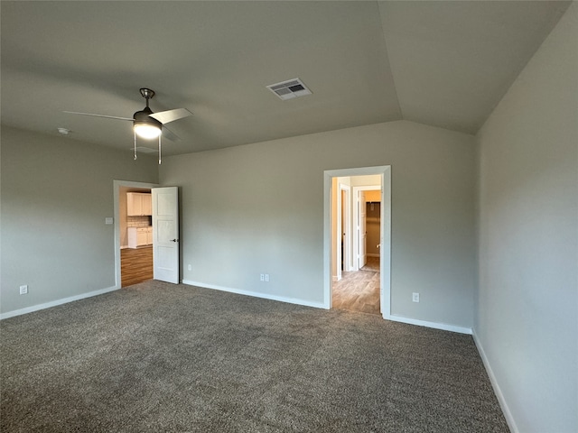 unfurnished bedroom with lofted ceiling, dark carpet, and ceiling fan