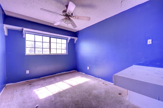 unfurnished room featuring ceiling fan, a textured ceiling, and carpet flooring