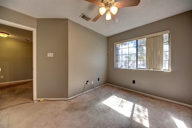 unfurnished room featuring ceiling fan, a textured ceiling, and light colored carpet