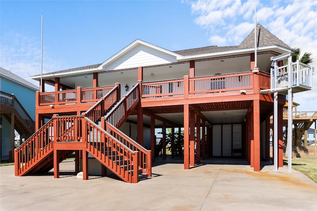 back of house with a wooden deck and a carport