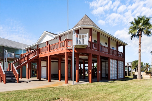 rear view of house featuring a patio area, a deck, and a lawn