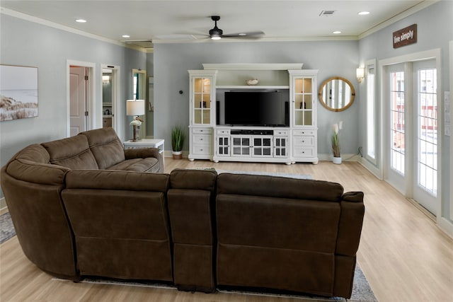 living room with crown molding, light hardwood / wood-style floors, and ceiling fan