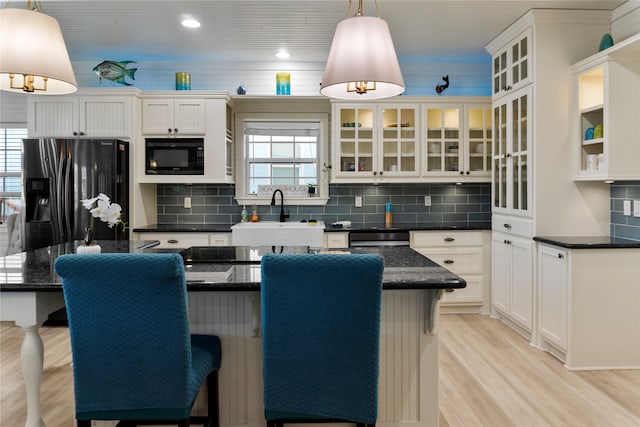 kitchen with a kitchen island, white cabinets, hanging light fixtures, and stainless steel appliances