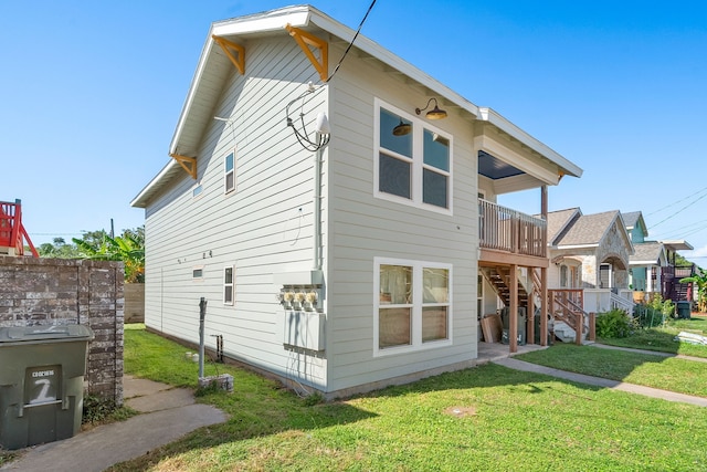 rear view of property featuring a yard and a deck