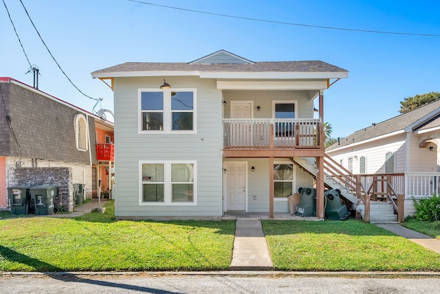 view of front facade with a front yard and a balcony