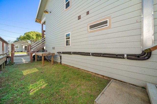 view of side of property featuring a wooden deck and a lawn