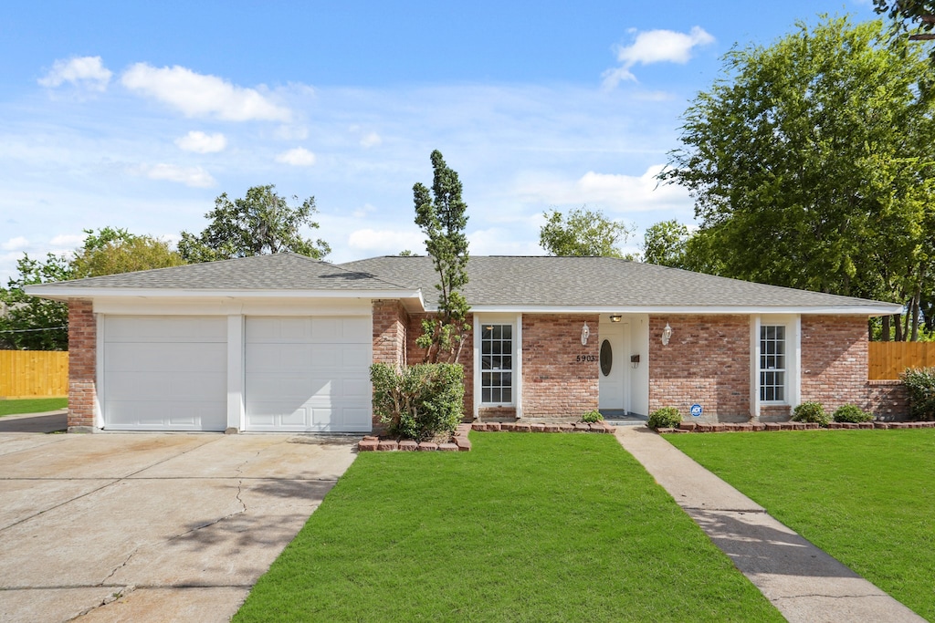 single story home with a front yard and a garage