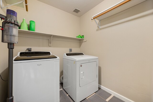 washroom with independent washer and dryer and a textured ceiling