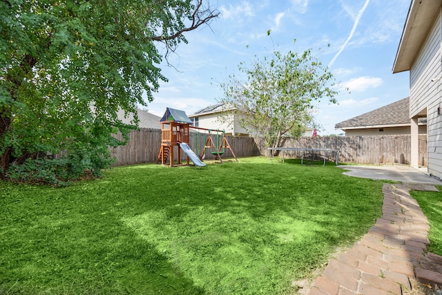 view of yard with a patio, a trampoline, and a playground