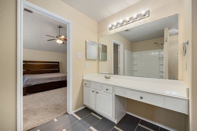 bathroom with vanity, a shower, and ceiling fan