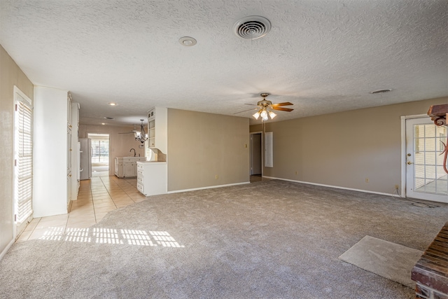 unfurnished living room featuring light carpet, a textured ceiling, sink, and ceiling fan